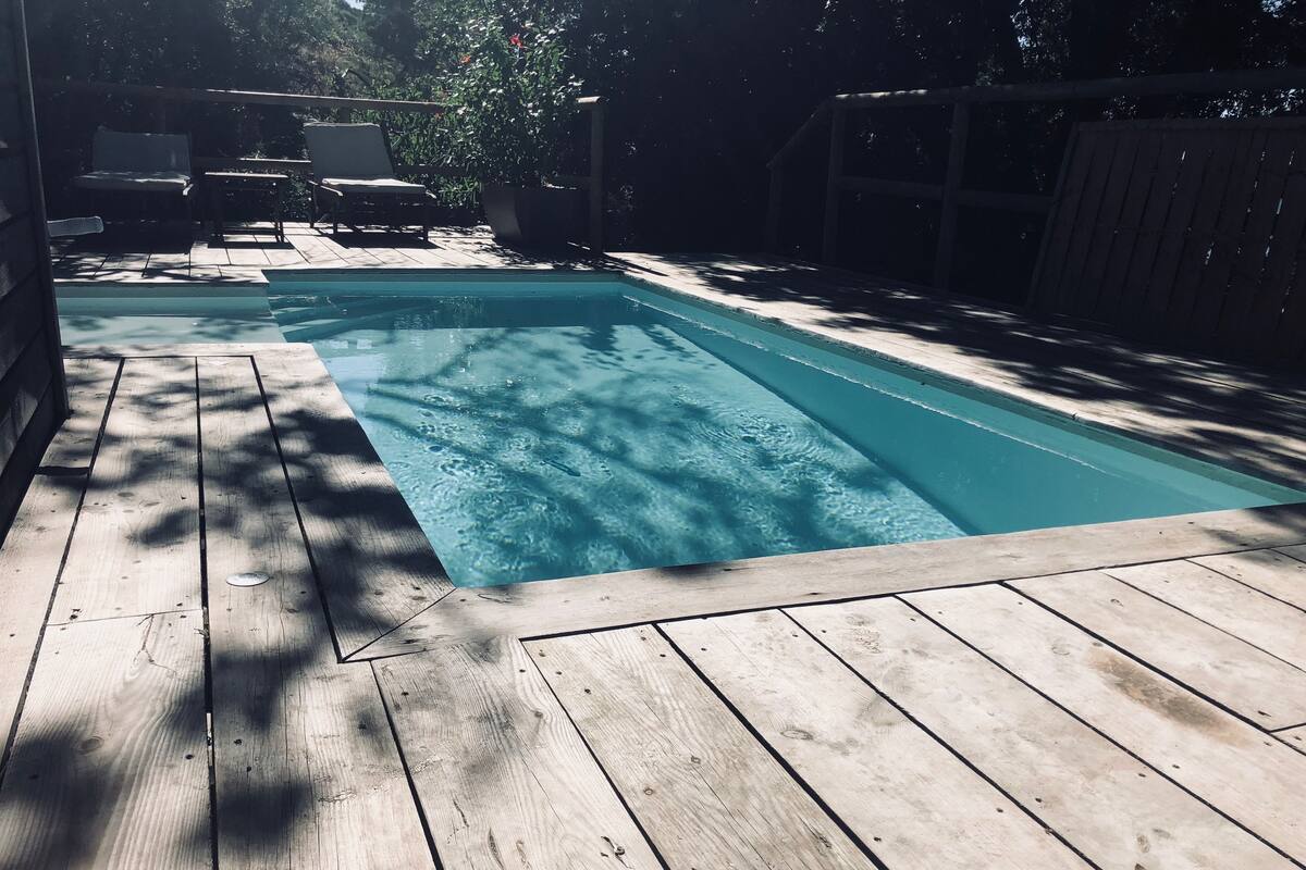 Ein Holzdeck mit einem Schwimmbecken.