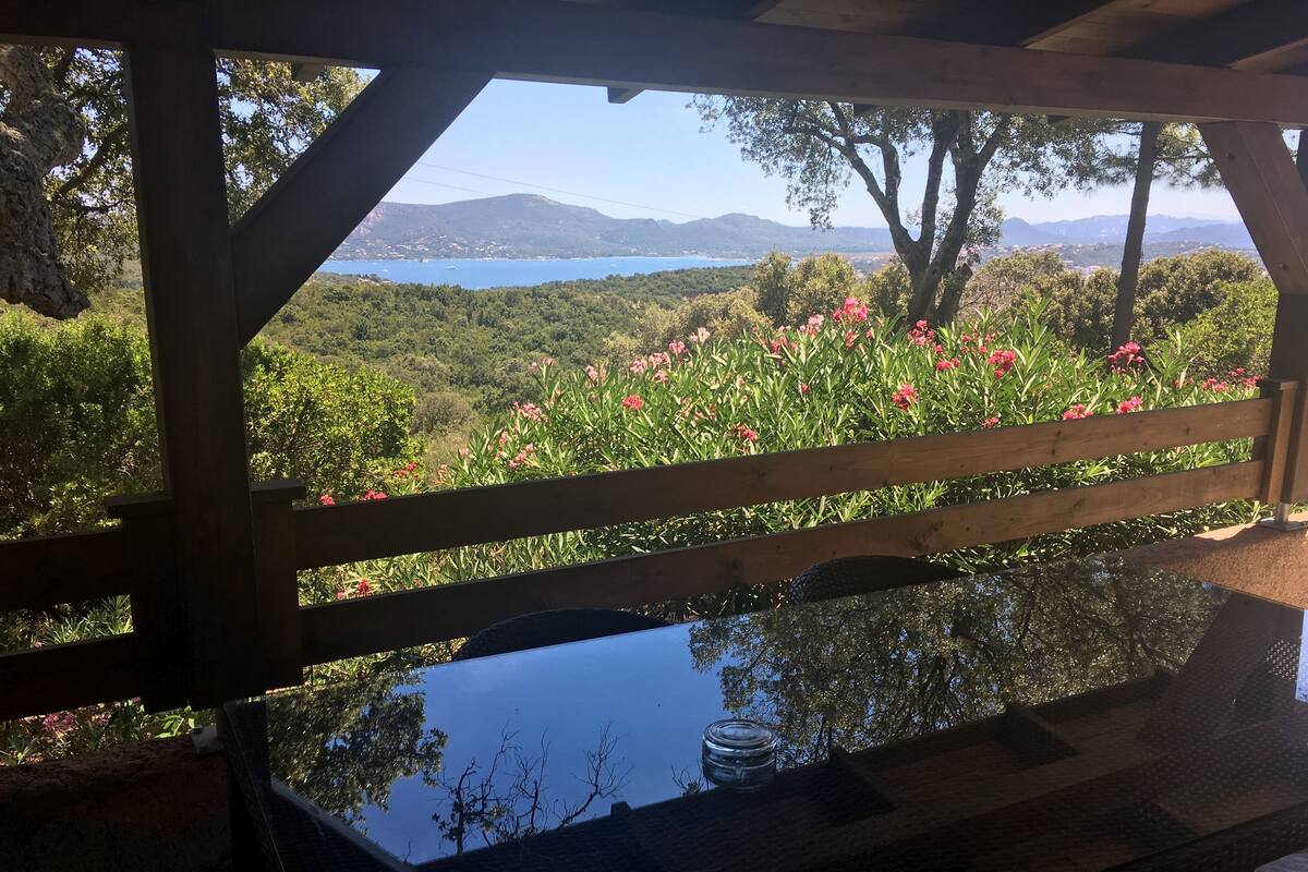 Eine Holzpergola mit Blick auf einen See und Berge.