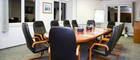 A conference room with a round table and eight chairs.