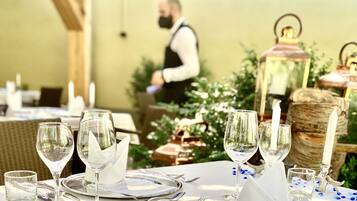 A table set for a meal with clear glassware, silverware, and a candle.