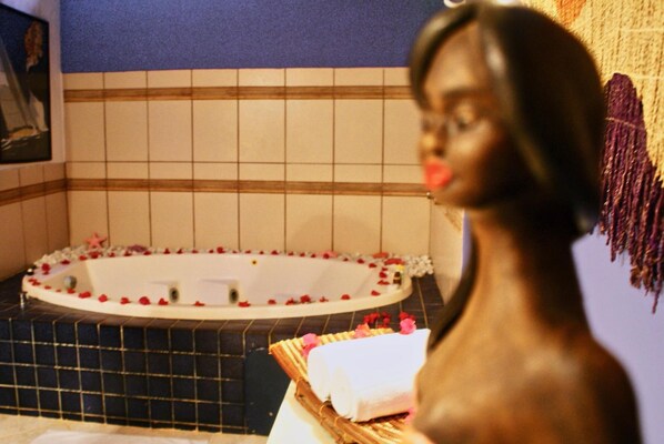 A bathtub with rose petals and a towel on a tray. - Porto da Lua (Mata de São João)