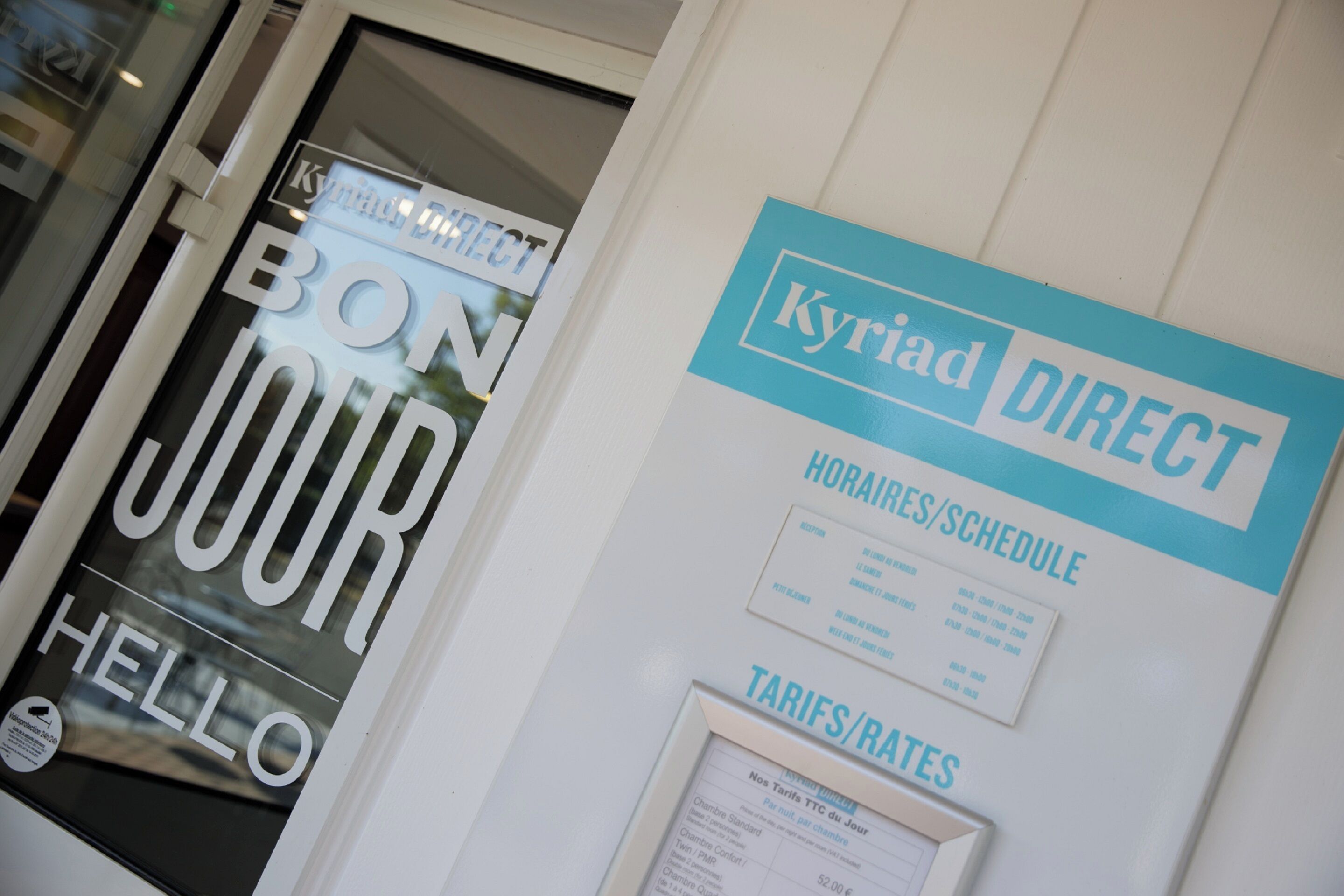 Un cartel para 'Kyriad Direct' con secciones tituladas 'HORARIOS' y 'TARIFAS'.