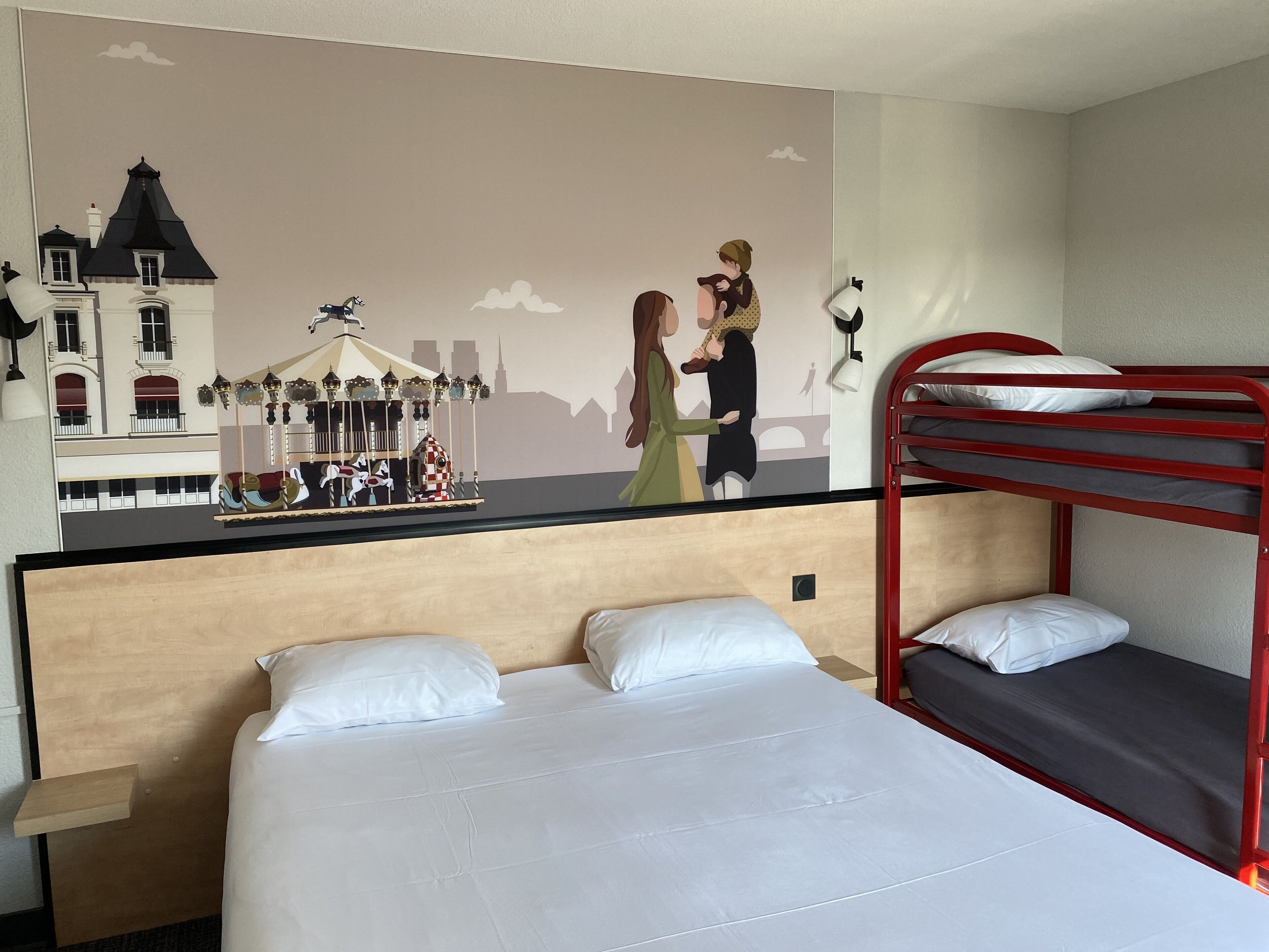 Hotelkamer met een stapelbed, een enkel bed, een houten hoofdeinde en een muurschildering van een stadsgezicht.