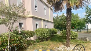 Una mesa con alimentos para el desayuno y una silla frente a un edificio con jardín.