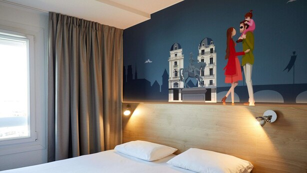 Habitación de hotel con cama, cortinas, un mural de una pareja en un puente y una ventana.