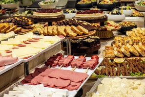 A buffet with various food items including meats, cheeses, and desserts. - Raymond Hotel Old City (Istanbul)