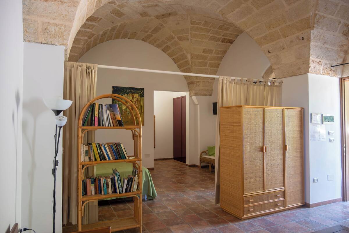 Una habitación con estantería, armario y lámpara.
