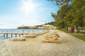 On the beach, white sand, sun-loungers, beach umbrellas
