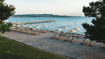 Sulla spiaggia, sabbia bianca, lettini da mare, ombrelloni