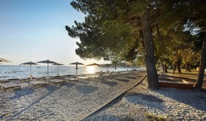 On the beach, white sand, sun loungers, beach umbrellas