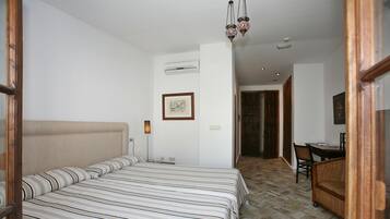 A hotel room with a large bed, a desk, and a chair.