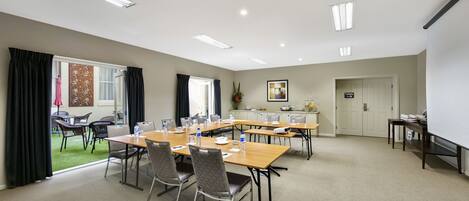 A conference room with a long table, chairs, and a whiteboard.