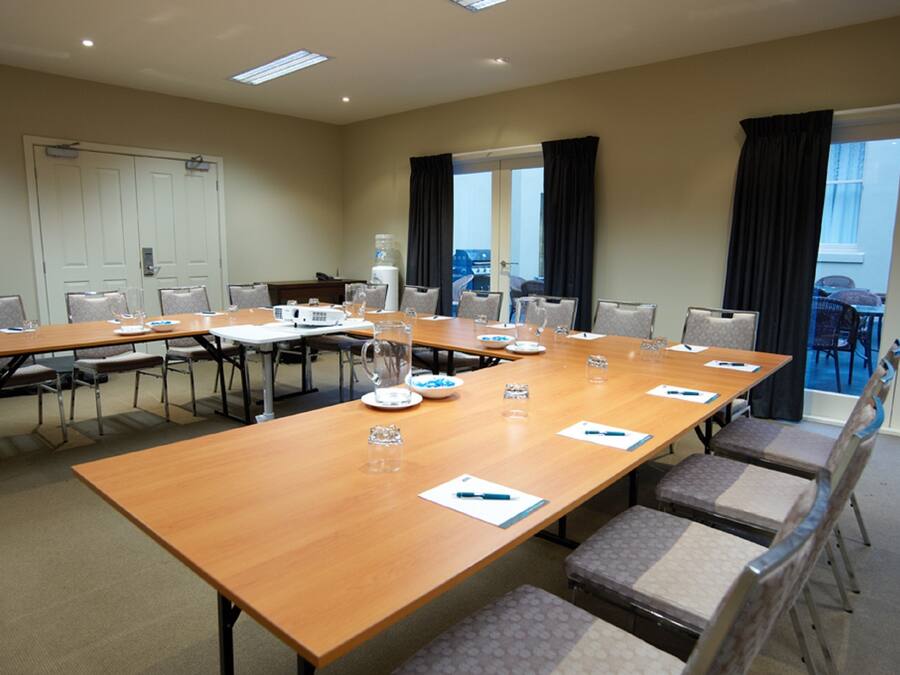 A conference room with a long table, chairs, and a water dispenser.