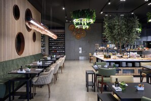Un restaurant doté d’un long comptoir, de plusieurs espaces pour s’asseoir et proposant une grande variété de plats et de boissons.