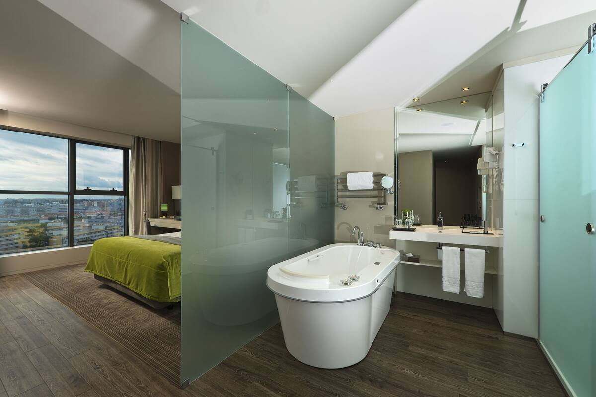 Een moderne badkamer met een vrijstaand bad, een douchecabine van glas en een wastafel met spiegel.