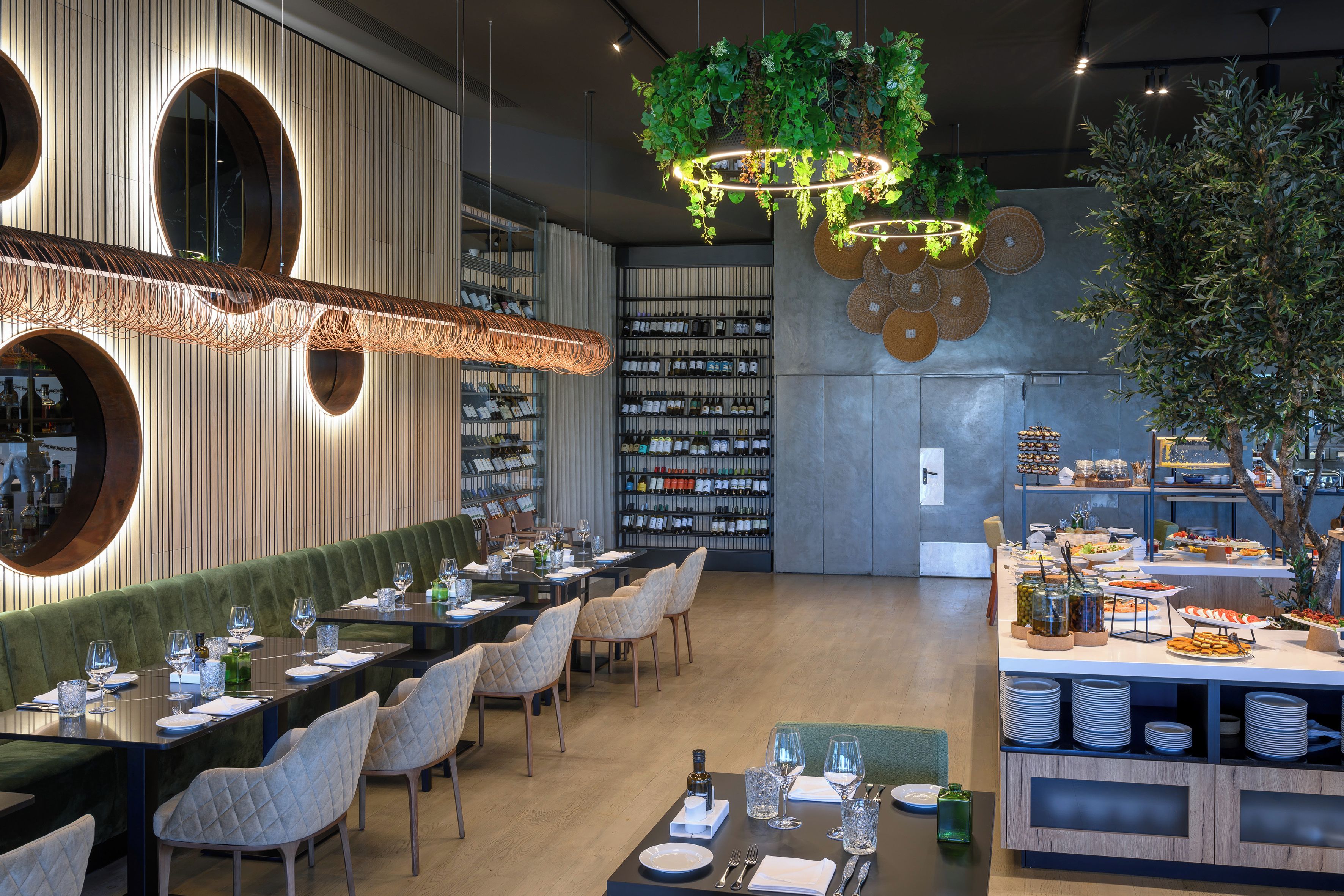 A restaurant with a long dining table, chairs, and a wine rack.