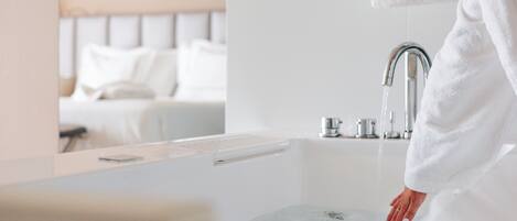 A bathroom with a bathtub, a faucet, and a mirror.