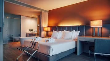 Una habitación de hotel moderna con una cama grande, mesitas de noche, un escritorio y una silla.