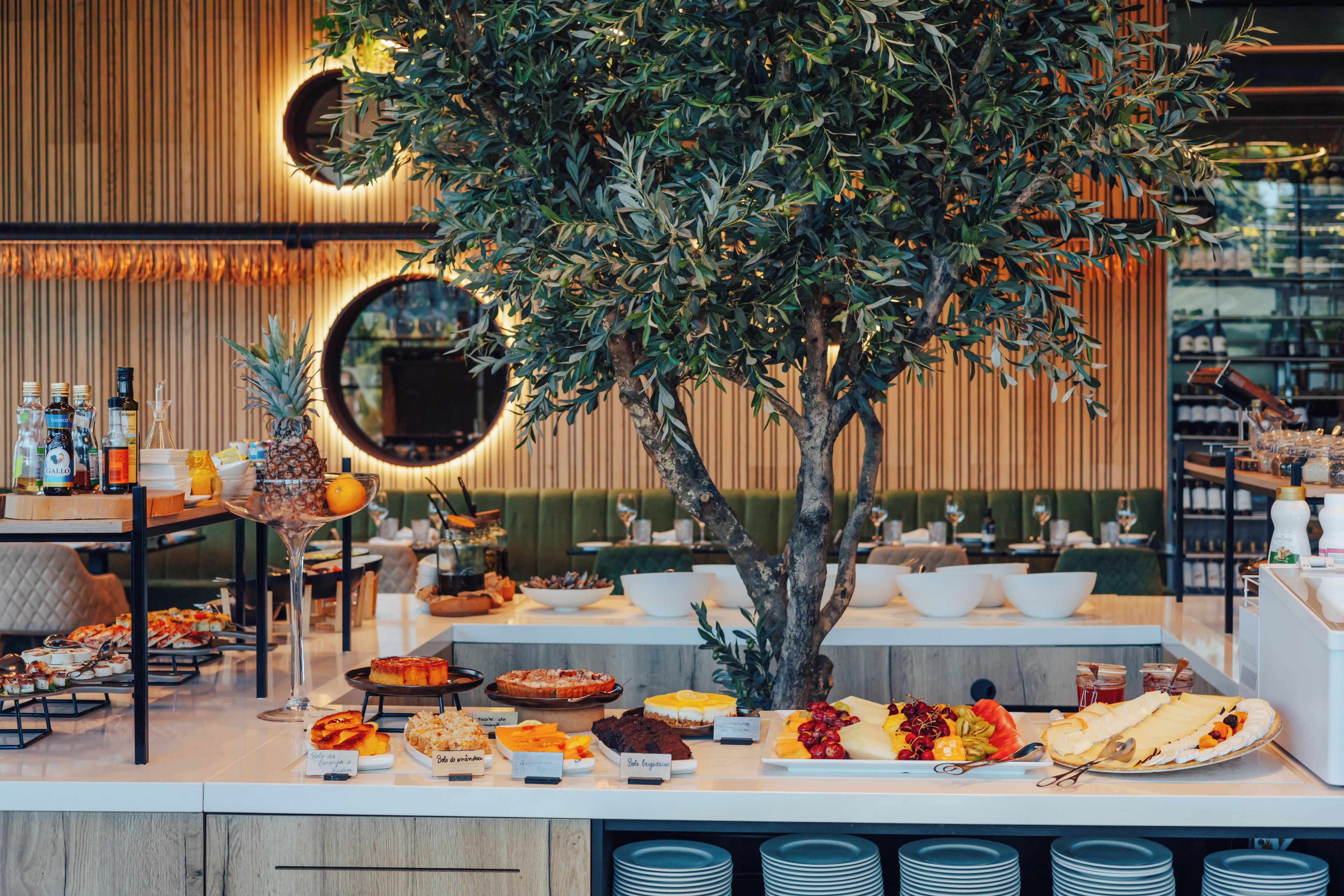 Montaje de bufé con diversos platos, un espejo y un centro de mesa con un árbol.