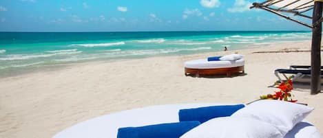 On the beach, white sand, sun loungers, beach umbrellas