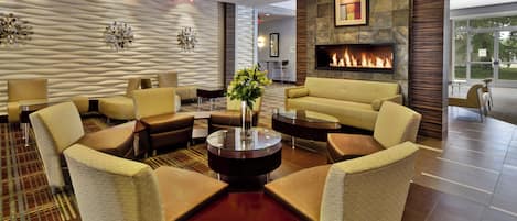 A modern lobby with a fireplace, comfortable seating, and a decorative wall.