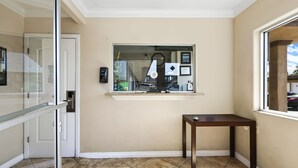 Ein Eckzimmer mit Glastür, einem kleinen Tisch und einem Fenster mit Blick auf die Straße.