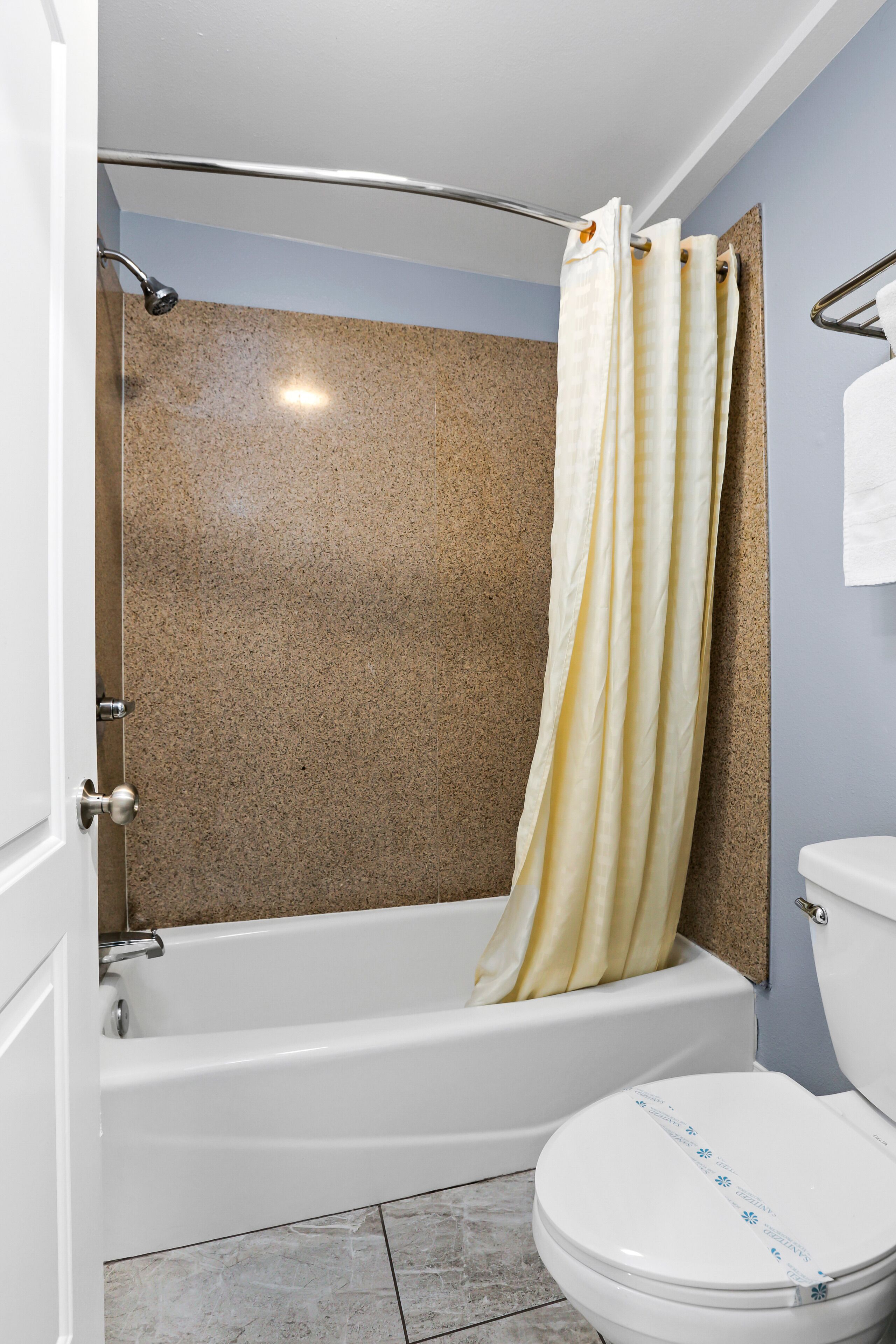 A bathroom with a bathtub, shower, and toilet.