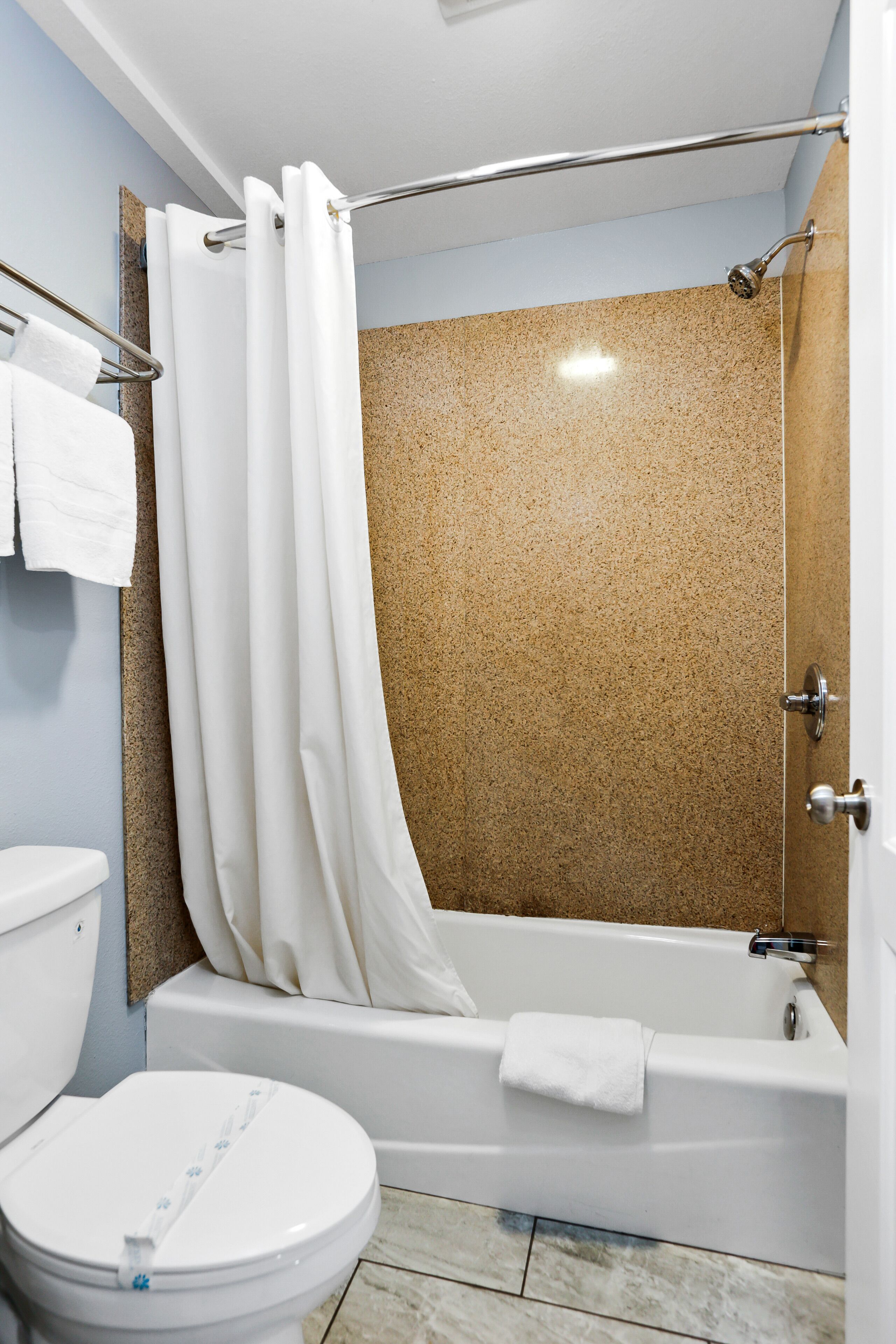 Une salle de bain avec une baignoire, des toilettes et un rideau de douche.