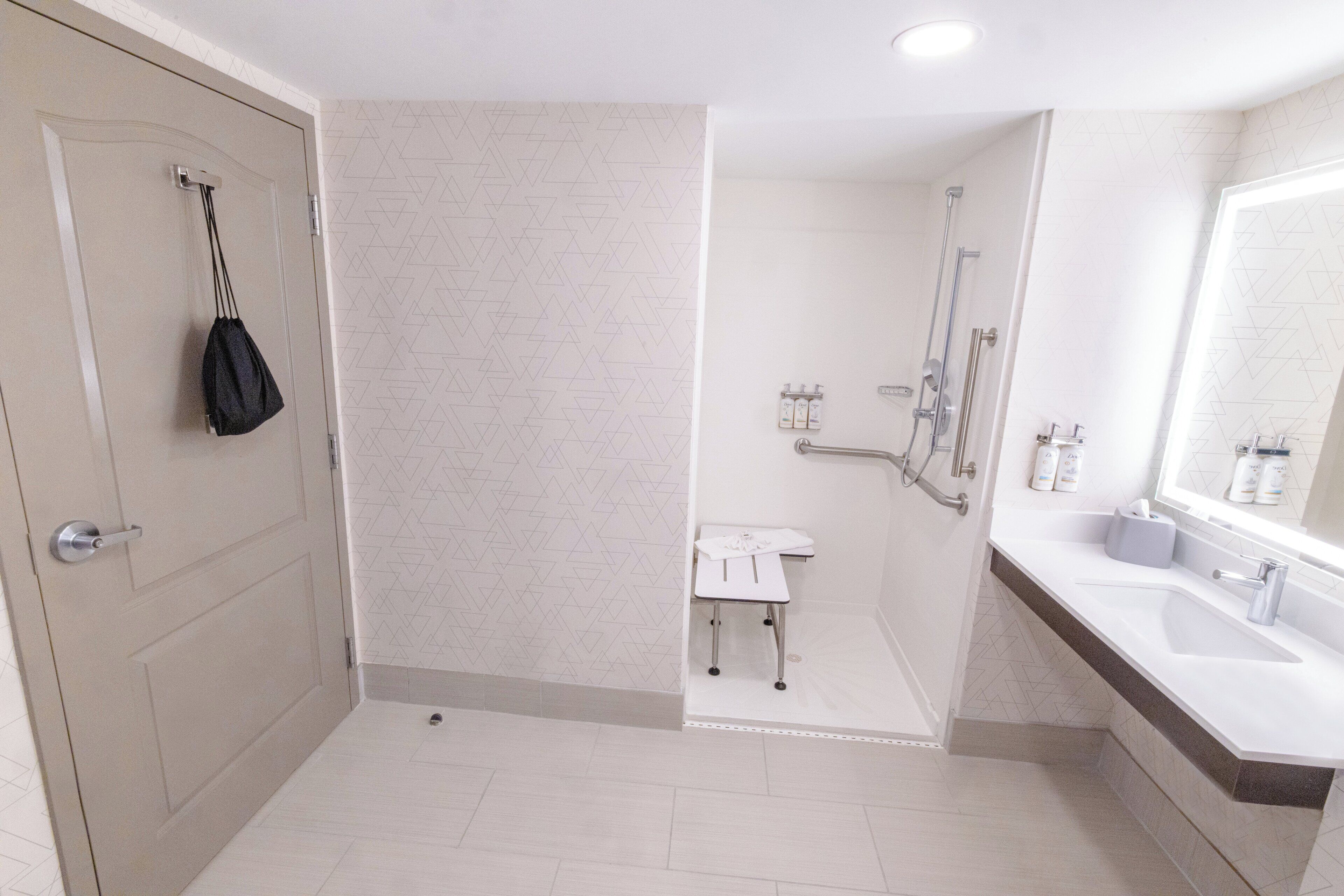 Een moderne badkamer met een douche, wastafel en toilet.