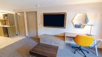 Una habitación moderna con escritorio, silla y televisión de pantalla plana montada en la pared.
