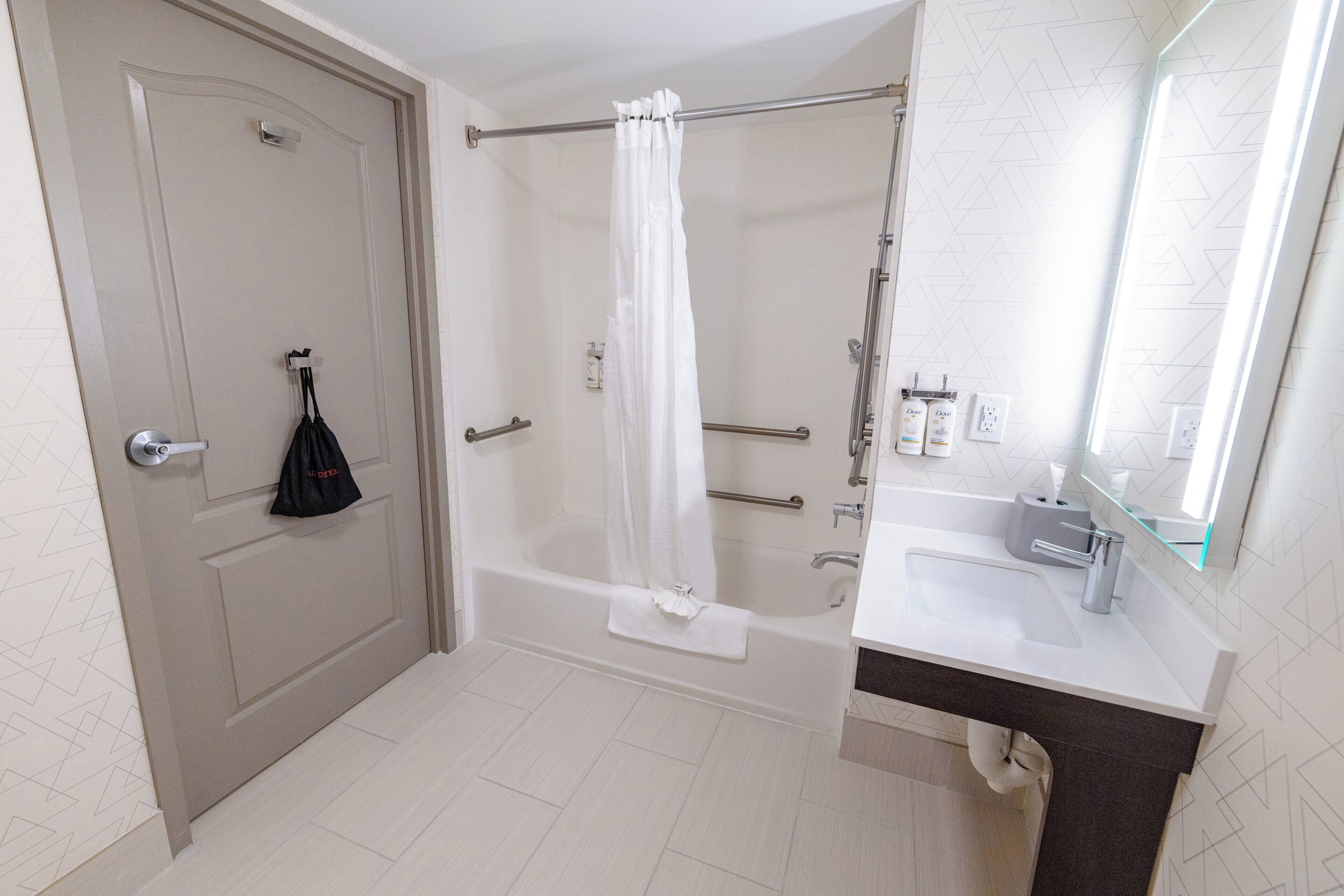 A modern bathroom with a bathtub, shower, and sink.