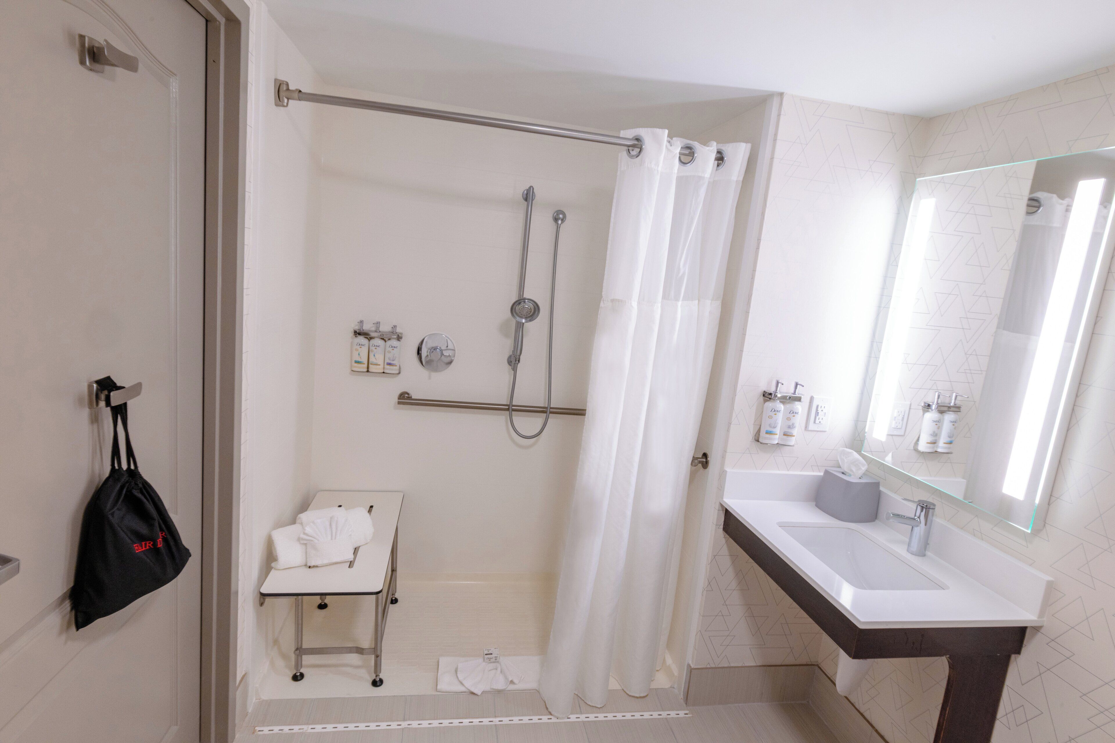 Un baño moderno con ducha, lavabo y toallero.