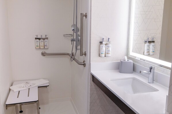 A modern bathroom with a shower, toilet, and sink.