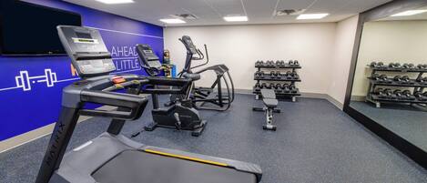 Una palestra con tapis roulant, ellittiche e una panca.