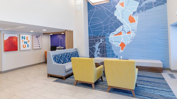 A modern lobby with a seating area, a map mural, and framed artwork on the walls.