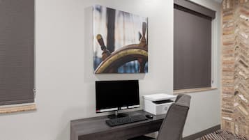 A modern office desk with a computer, printer, and chair.