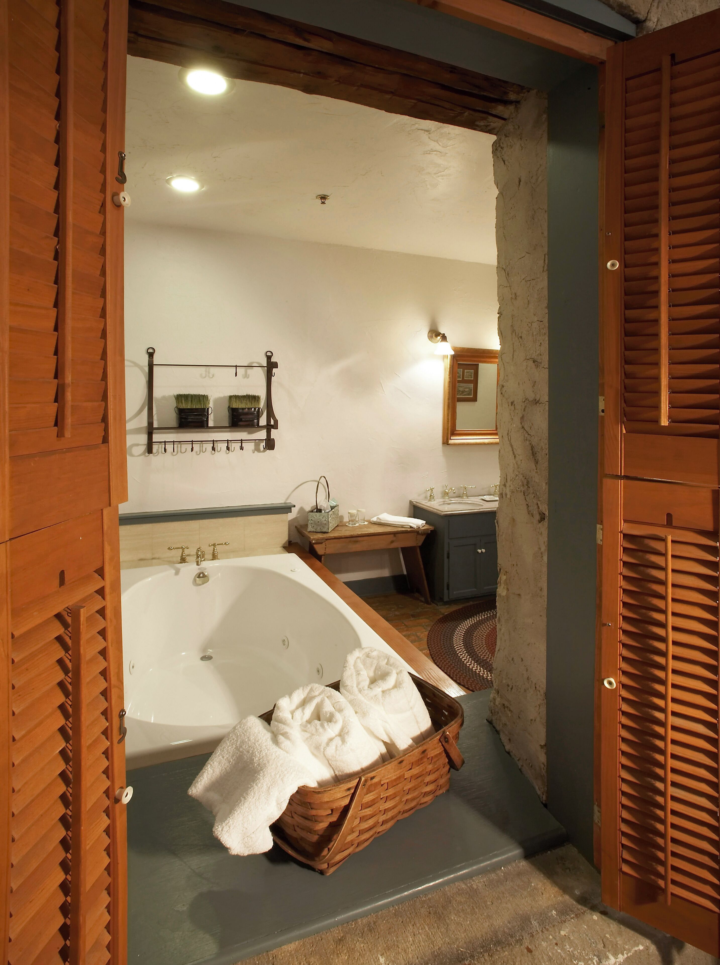 A bathroom with a bathtub, a sink, and a wooden bench.
