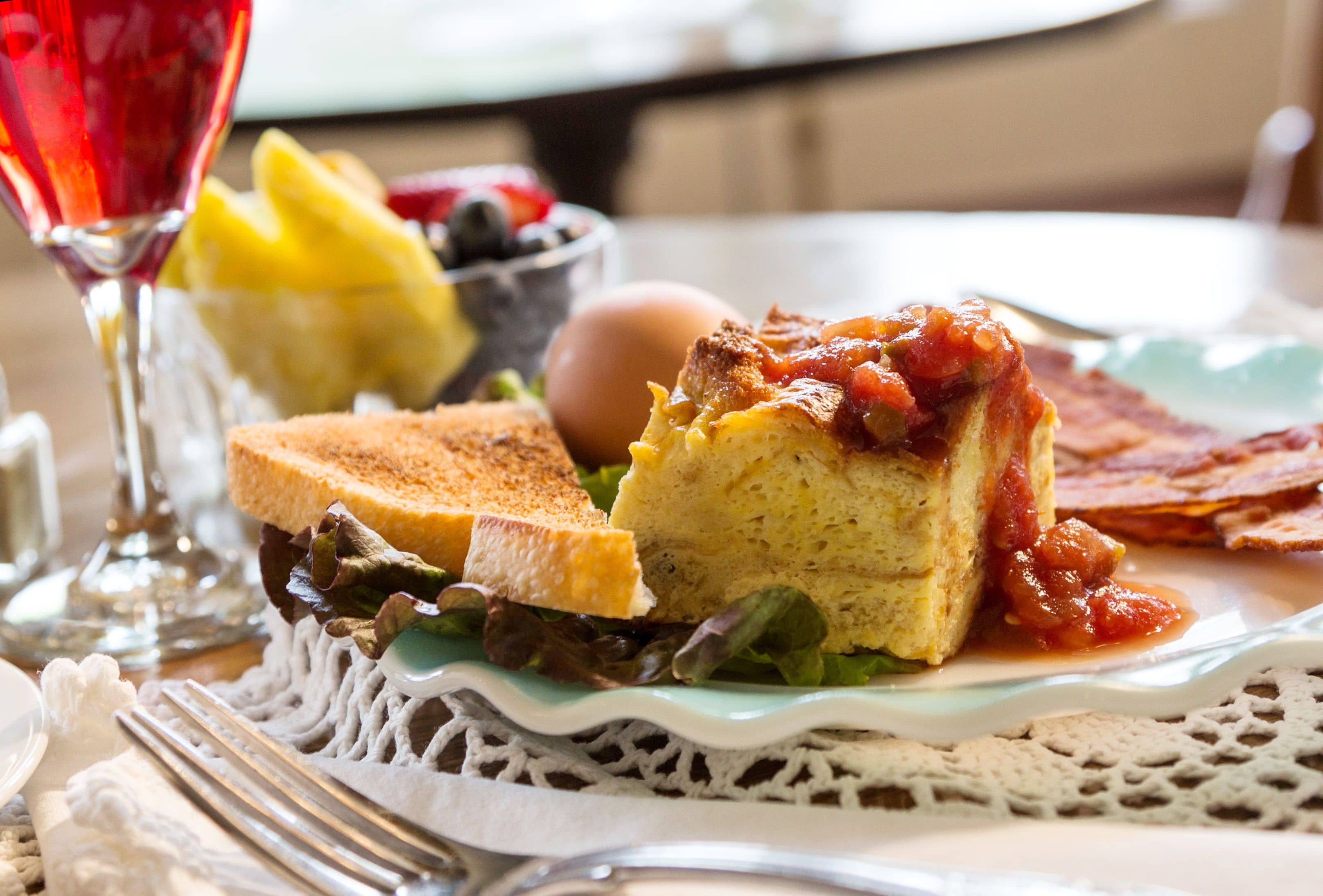 Un plato de desayuno con tostadas, un huevo frito y salsa de tomate.