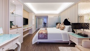 Een moderne hotelkamer met een groot bed, een bureau, een televisie en een inloopkast.