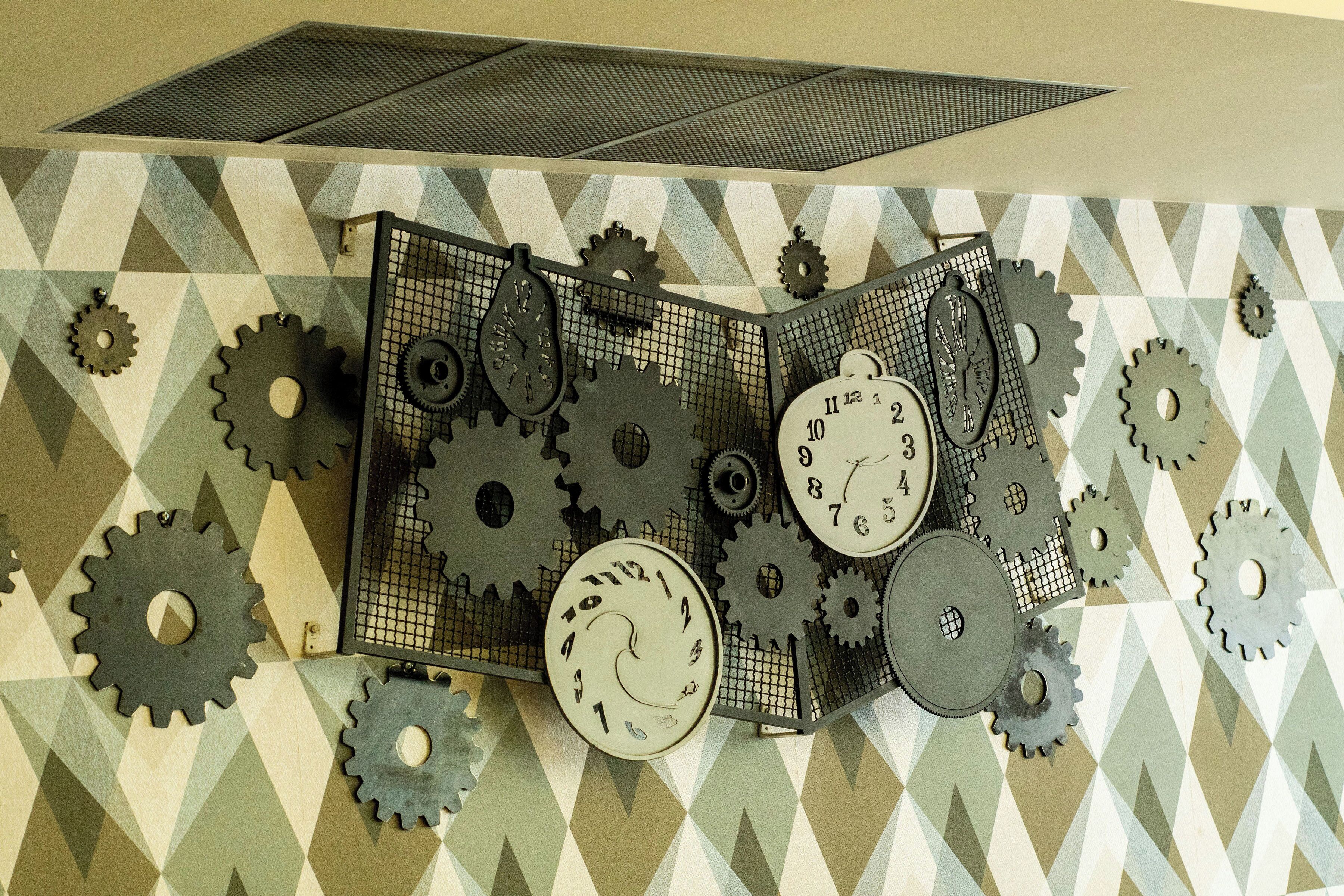 A wall with geometric patterned tiles and a clock with gears.
