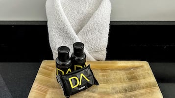 Una bandeja de madera con dos botellas negras y un paquete negro etiquetado 'DA' sobre una encimera.