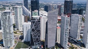 A high-rise urban area with modern buildings, including a distinctive triangular structure and several high-rise residential and commercial buildings.