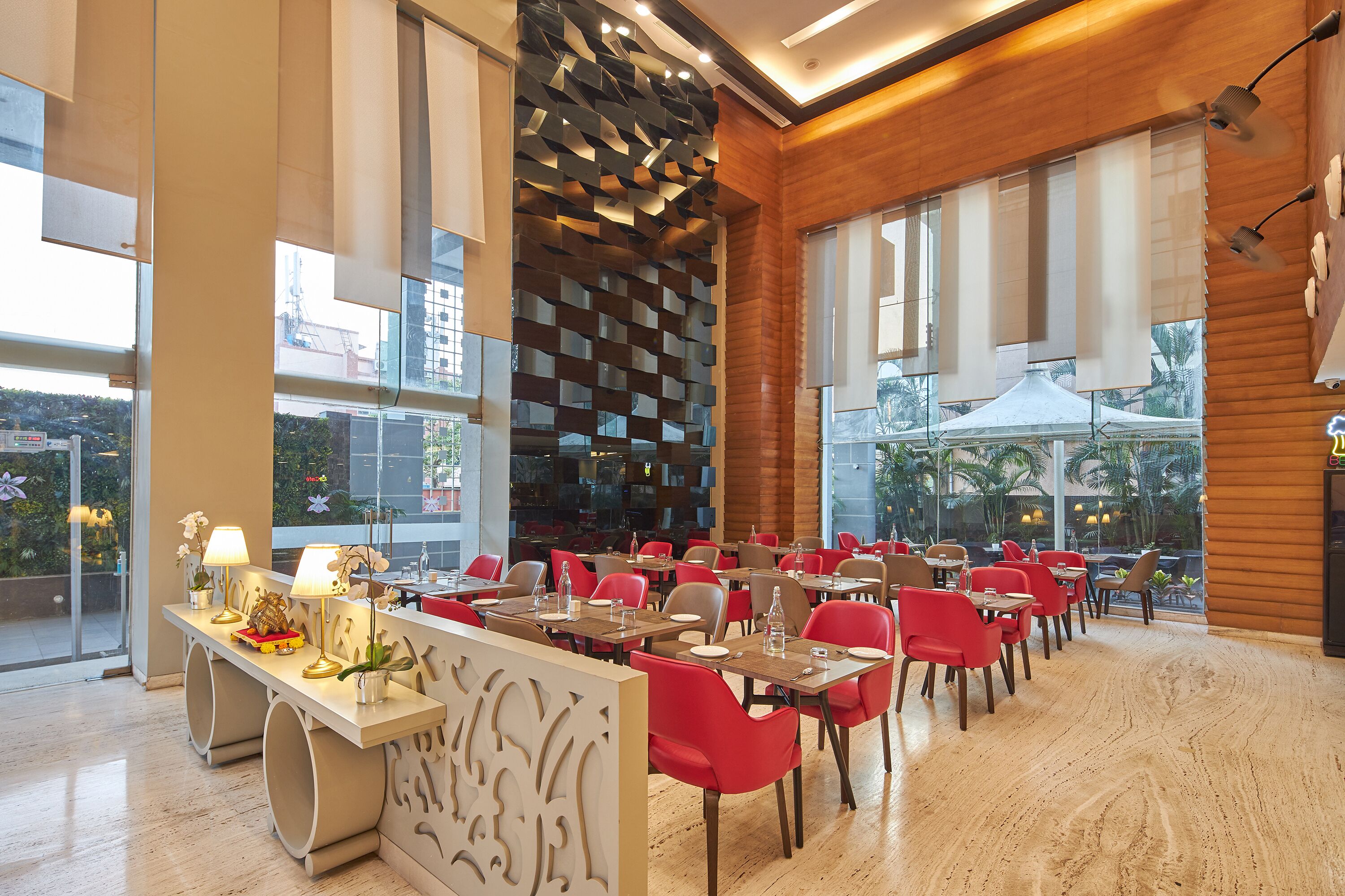 A modern dining area with tables and chairs, large windows, and a decorative wall.