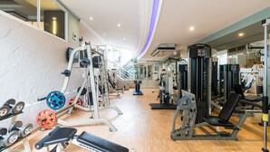 Une salle de sport équipée de divers appareils d’entraînement, notamment des appareils de musculation, des poids libres et des appareils de cardio.
