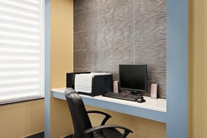 A small office space with a desktop computer, a printer, and a monitor on a white desk. - Baymont Inn And Suites Ft. Leonard/saint Robert (St. Robert)