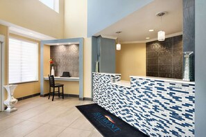 A reception area with a tiled counter, a desk, and a chair. - Baymont Inn And Suites Ft. Leonard/saint Robert (St. Robert)
