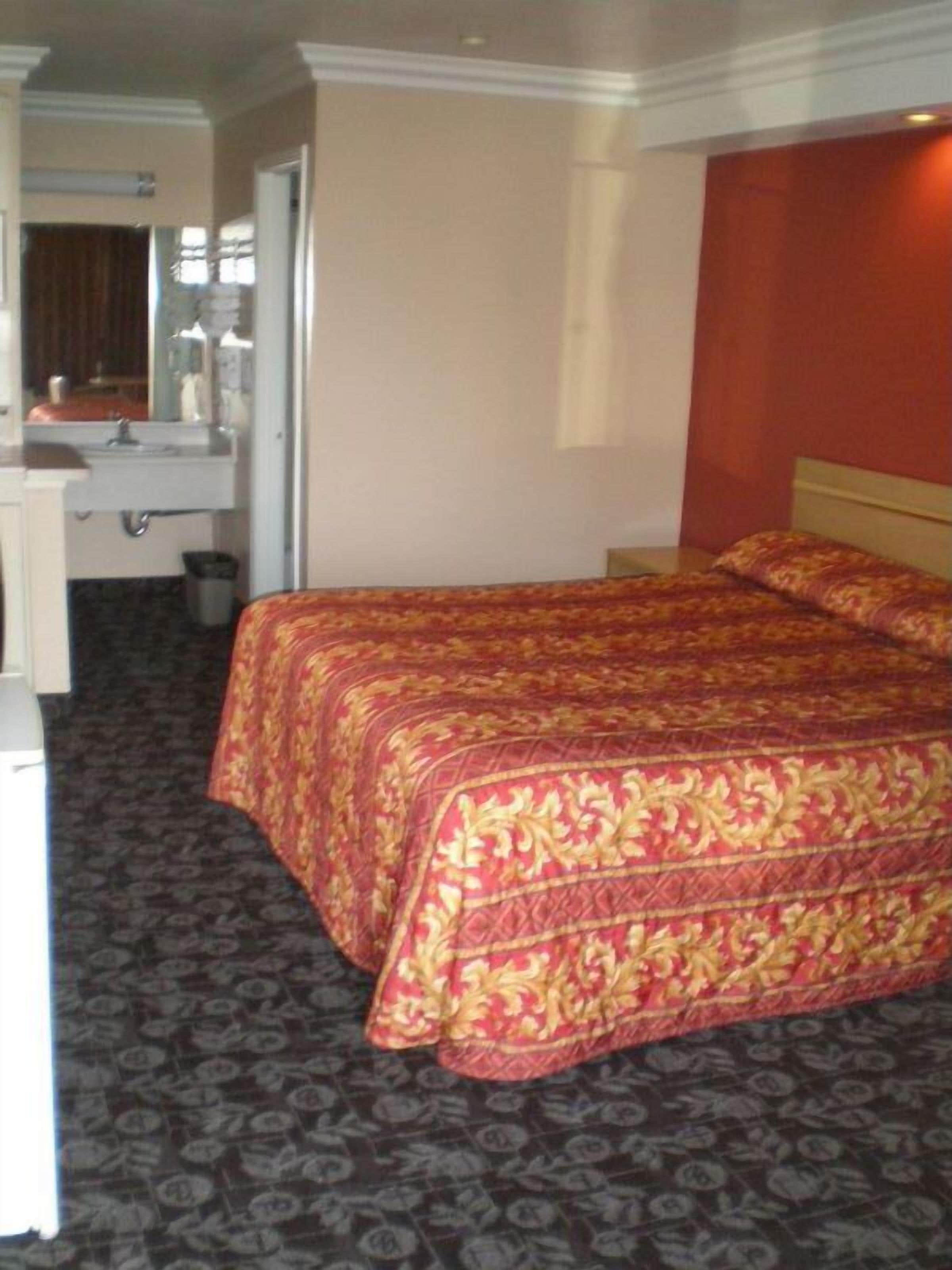 Una habitación de hotel con una cama, un escritorio y un espejo.