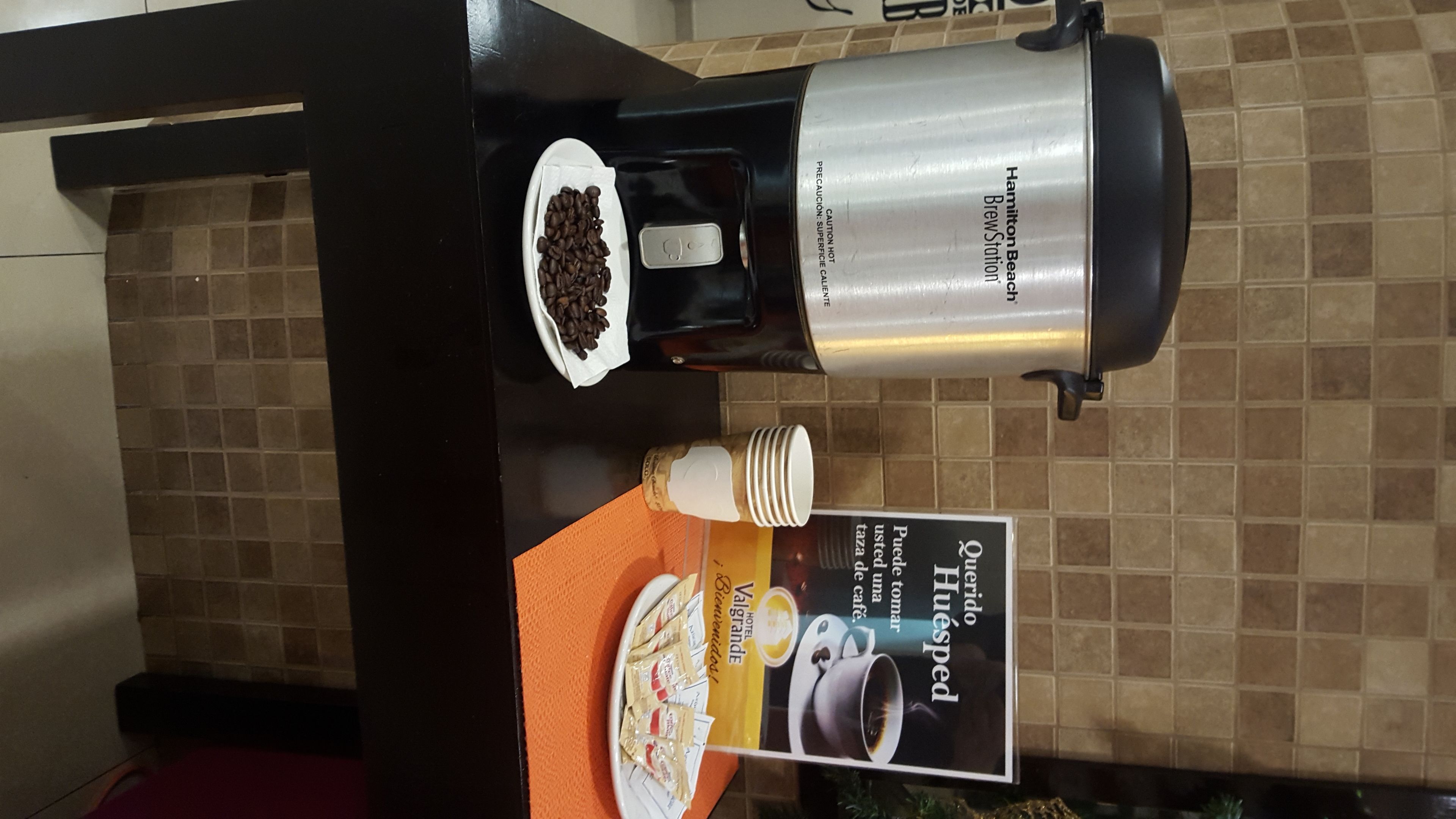 Une machine à café avec une verseuse et un support pour les dosettes de café, posée sur un plan de travail de cuisine.