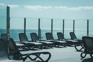 A deck with sun loungers facing the ocean. - Apartamentos El Palmar (San Bartolomé de Tirajana)