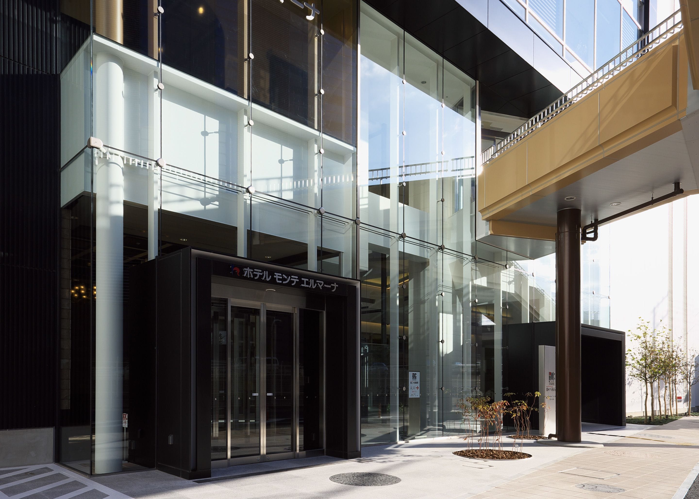 A modern building with large glass windows, a black entrance, and a sign in Japanese.